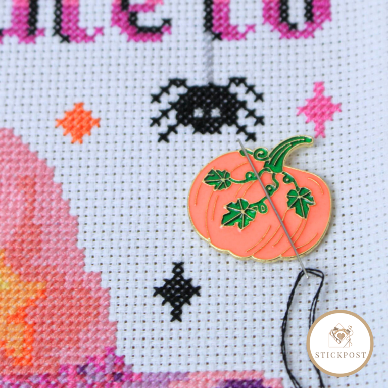 Herbstkürbis Nadelmagnet. orangefarbener Kürbis mit grünen Blätterranken. Angewendet auf einem Stickbild. Zeigt wie die Magnethalterung die Sticknadel hält.